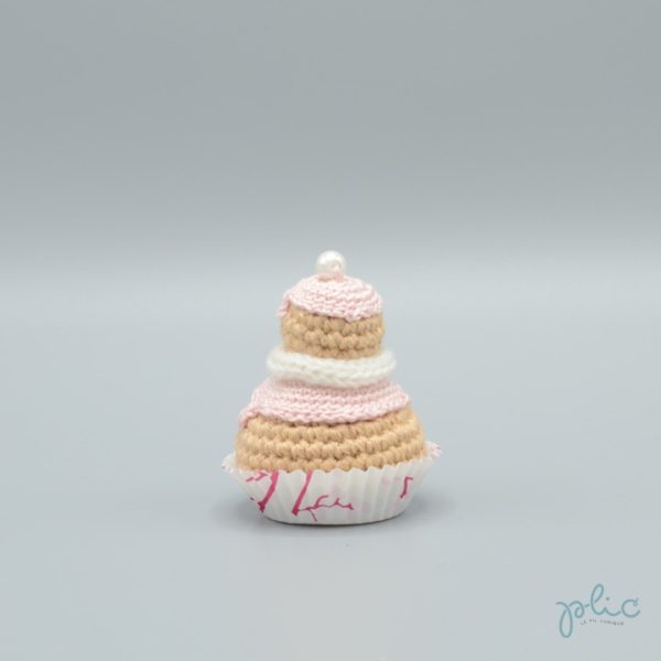 petit gâteau de 6,5cm de haut, composé de 2 choux crochetés superposés, recouverts de disques rose pâle crochetés, d'un tour blanc au tricotin et d'une perle nacrée, le tout réalisé par Plic.