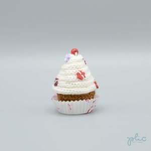 petit gâteau de 6,5cm de haut, recouvert d'un cône blanc réalisé au tricotin par Plic et décoré de petites perles colorées