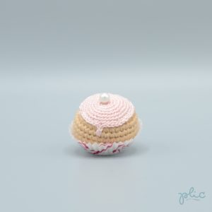 petit chou de 4cm de haut crocheté, recouvert d'un disque rose pale crocheté et d'une perle nacrée, le tout réalisé par Plic.