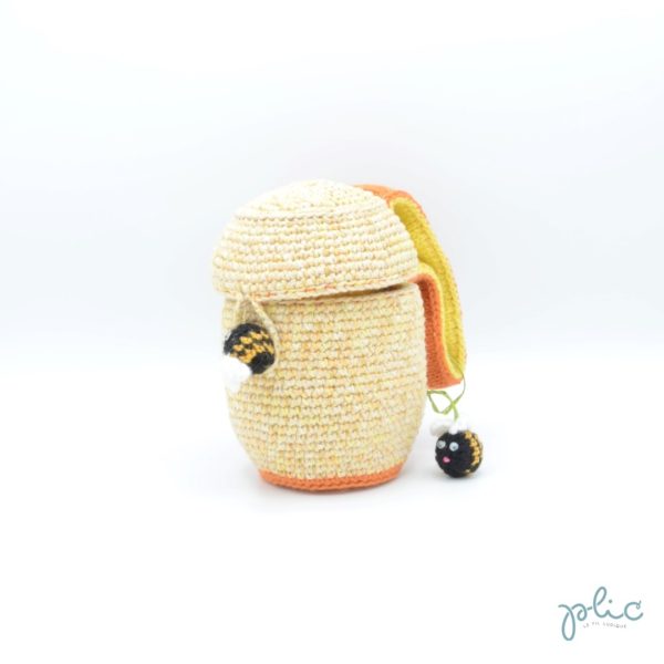 Sac aumônière de 16cm de haut et12cm de diamètre, muni d'une anse de 13cm et représentant une ruche décorée de 2 abeilles, le tout crocheté par Plic.
