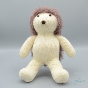 Peluche de 30cm de haut représentant un hérisson, tricotée par Plic.